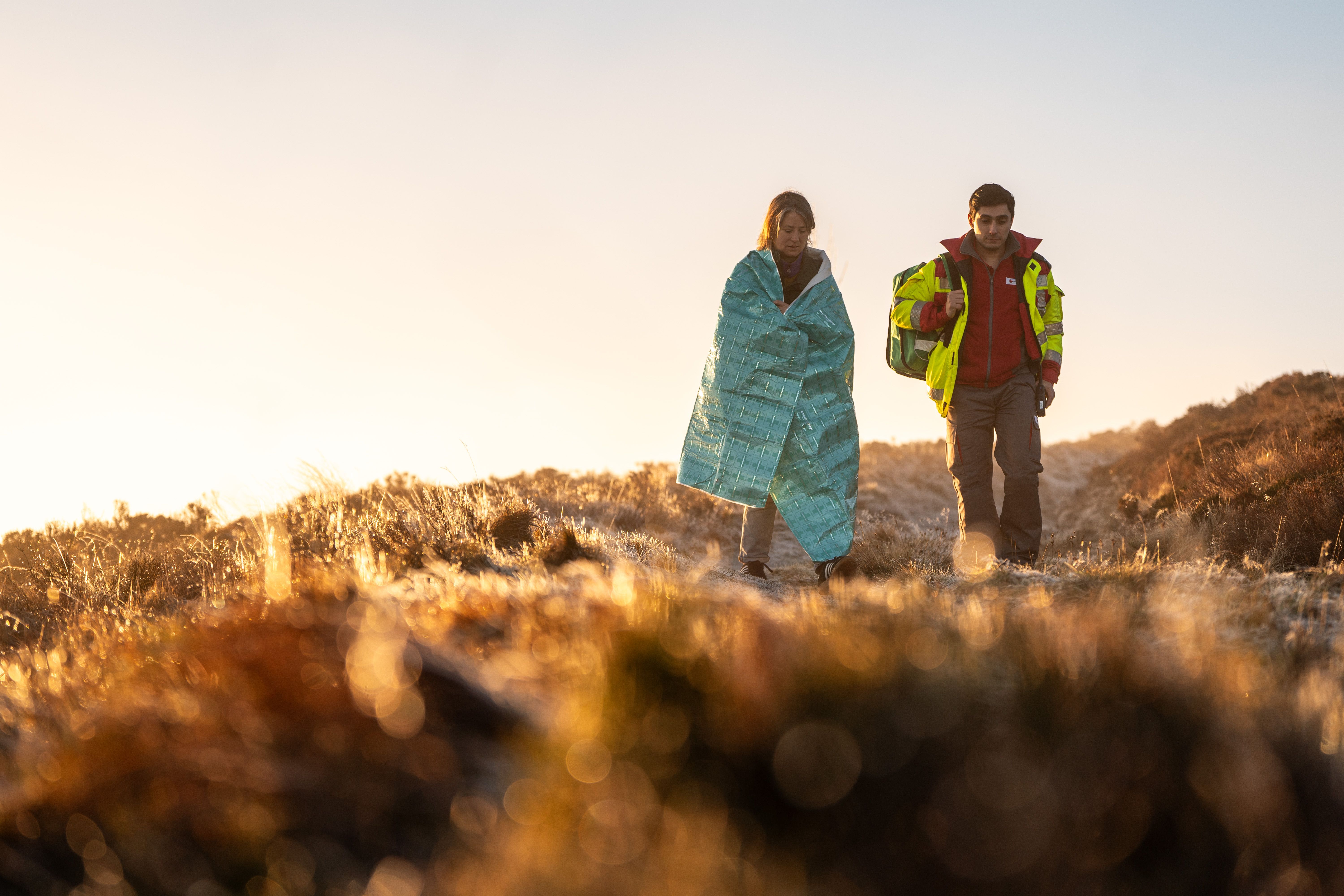 Two people walking across a field 