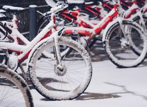 a-row-of-red-bikes-covered-in-snow