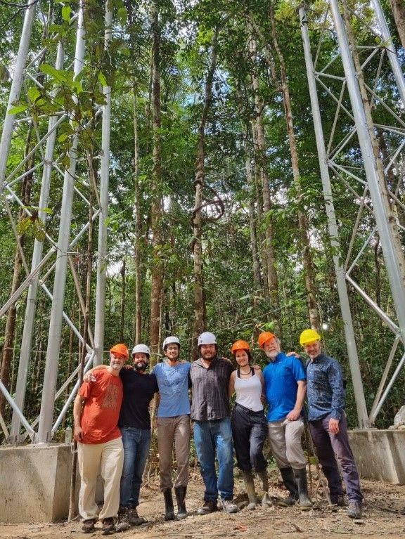 Project Oversight Group (POG) members including Dr Tomas Domingues, Professor Beto Quesada, Professor David Lapola, Dr Bruno Tanaka, Dr Sabrina Garcia, Dr Richard Norby and Professor Richard Betts at the inauguration of the AmazonFACE site. Behind them is the first site with six tower foundations and two towers that will soon form one completed ring.