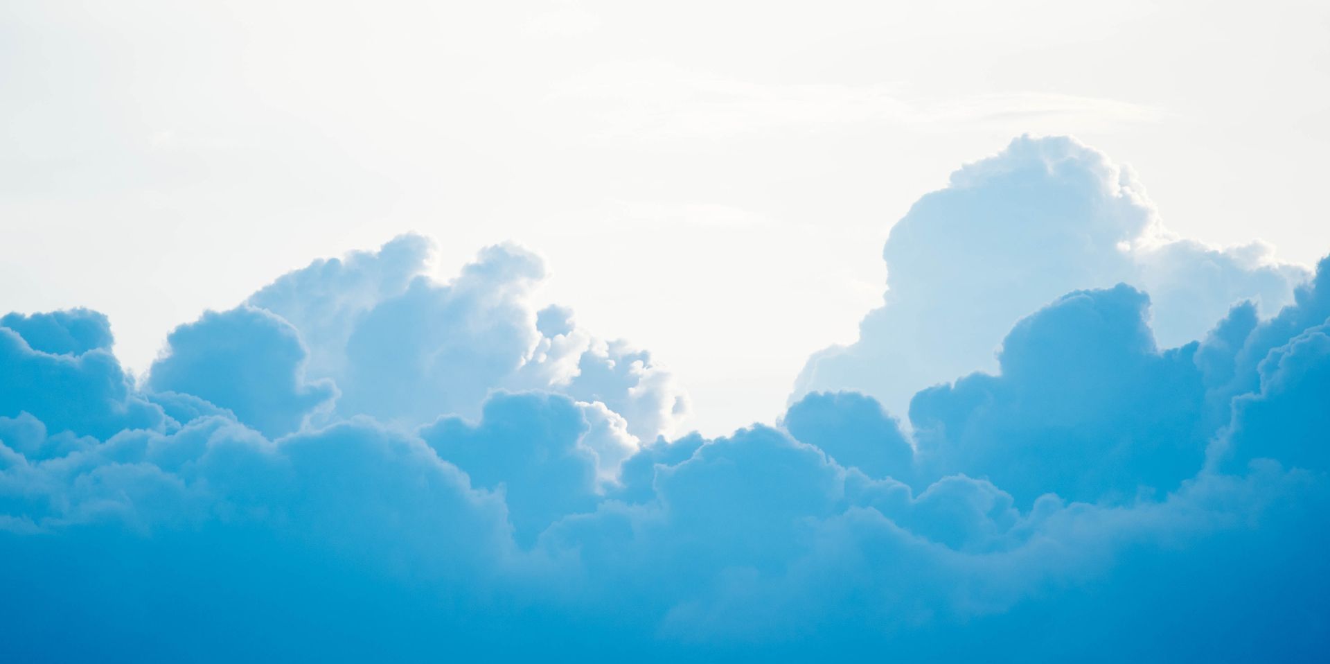 Blue clouds sitting beneath a bright sky