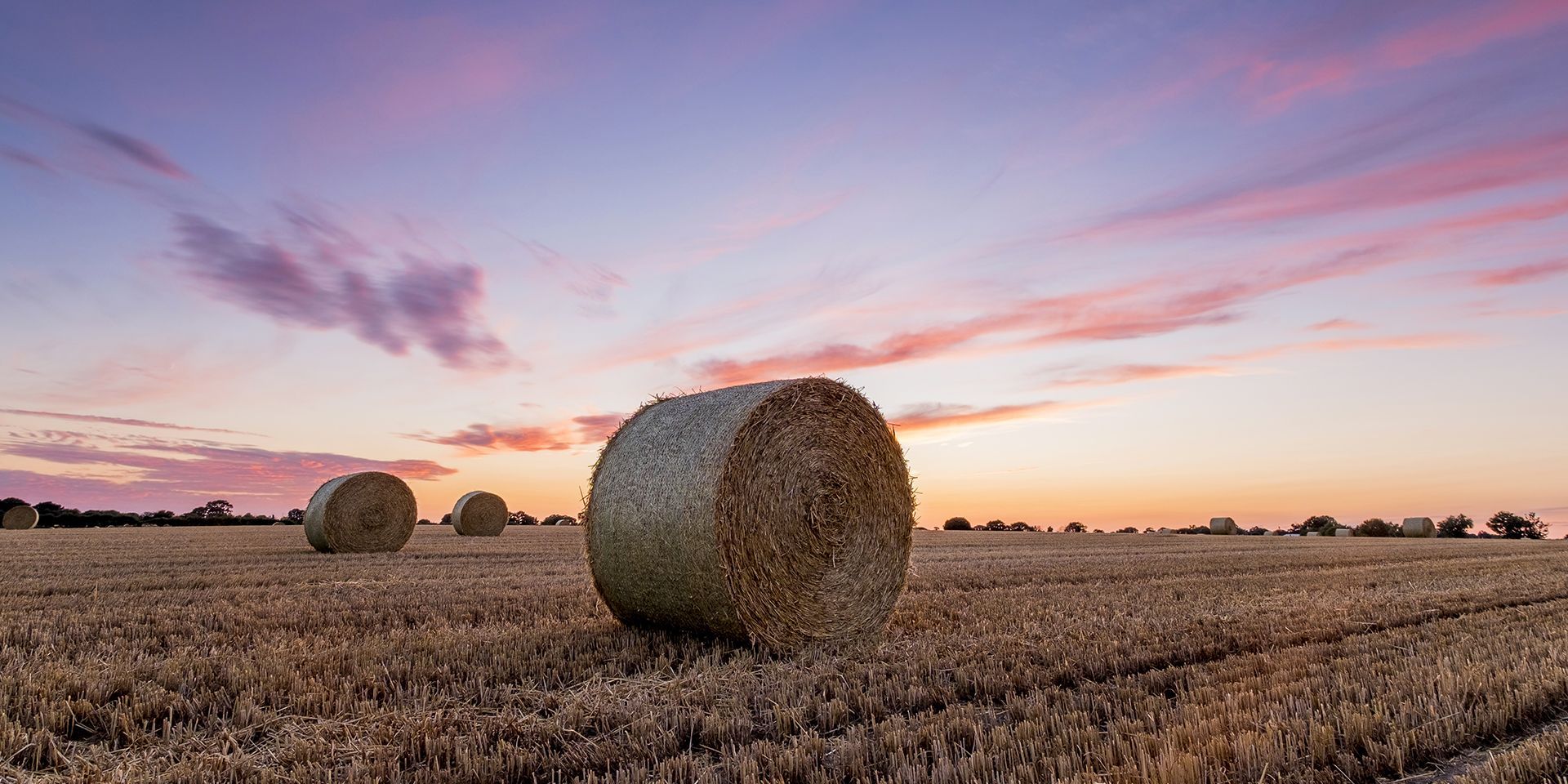 haybales-in-a-field-with-colourful-skies