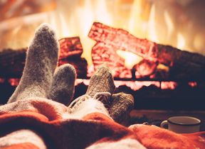 people-putting-their-feet-up-to-a-warm-fire