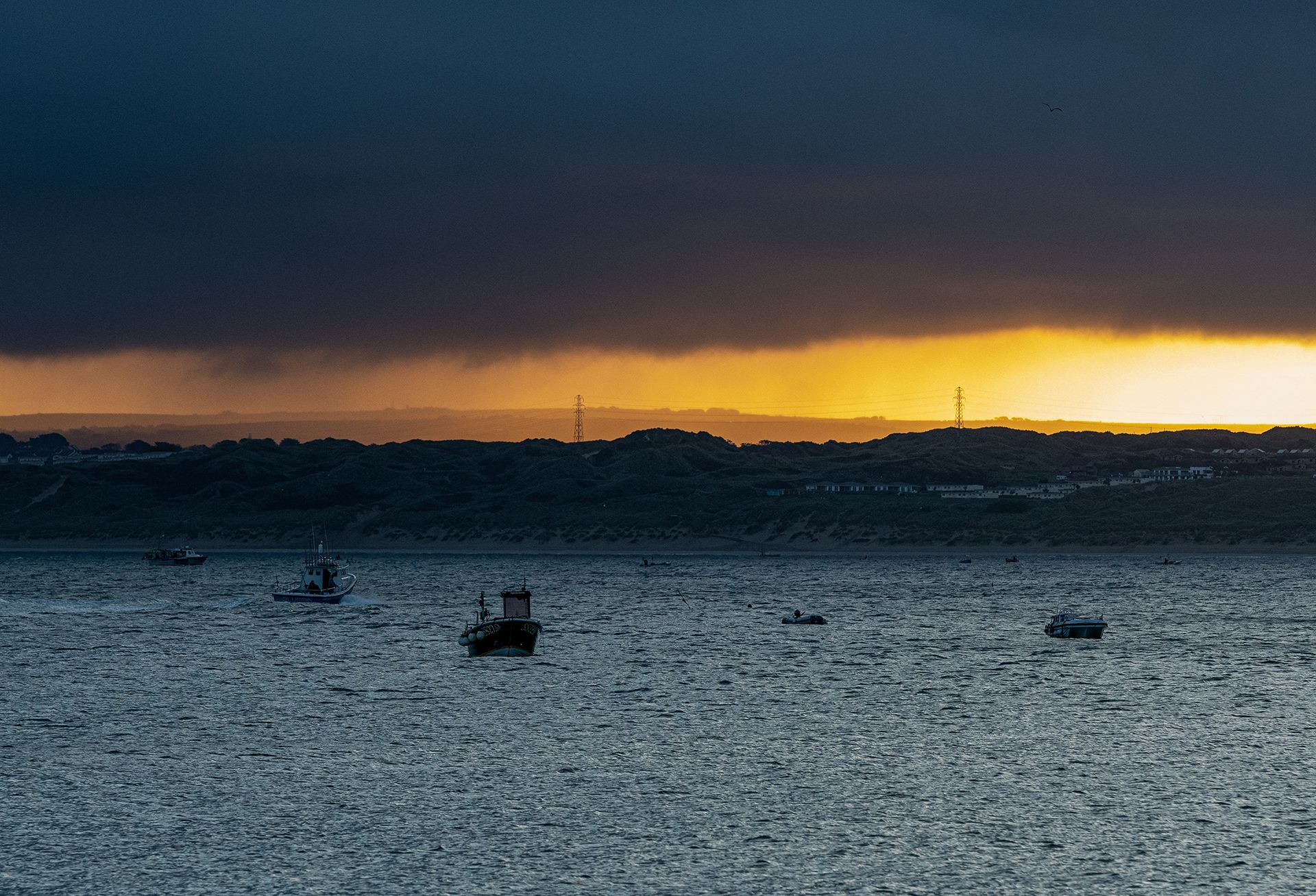 rain-clouds-over-boats-in-the-sea-at-sunrise-in-cornwall-uk.