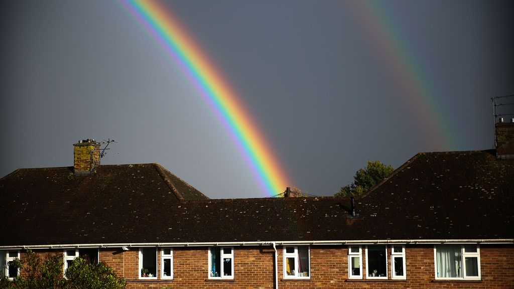 A double rainbow over rooftops showing the fainter outer arc
