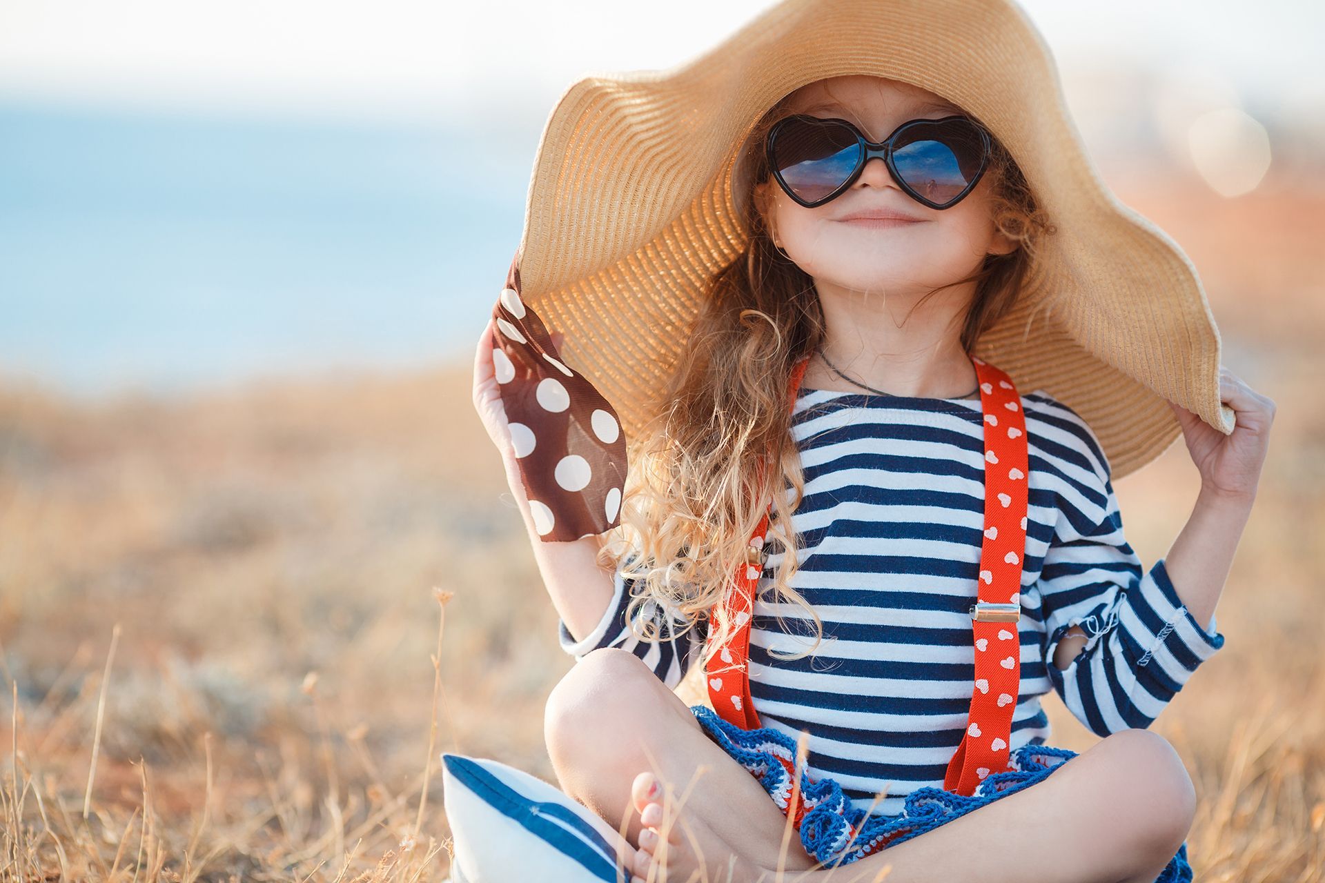 A young girl in a hat and sunglasses
