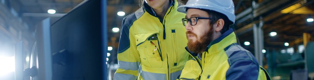 Two engineers on a building site looking at a computer screen
