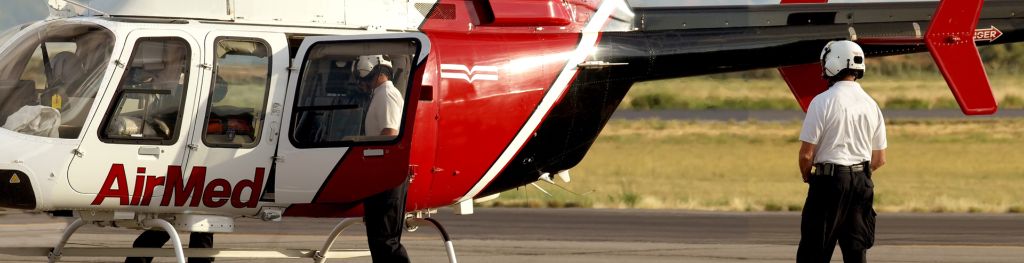 Medical evacuation helicopter and crewmen at airport.