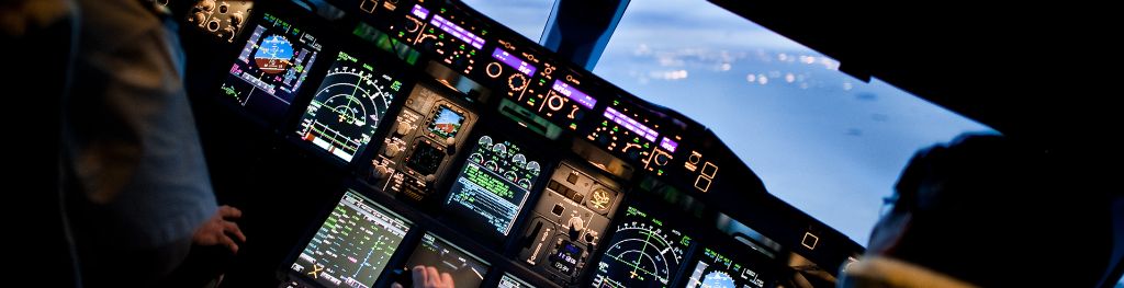 On-board instruments and pilots inside the cockpit of a commercial aircraft.