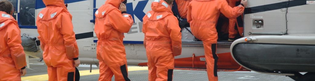 The crew of an oil platform climb aboard the transport helicopter, single-file.