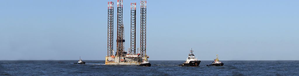 An oil platform towed into the port of Rotterdam by tug boats