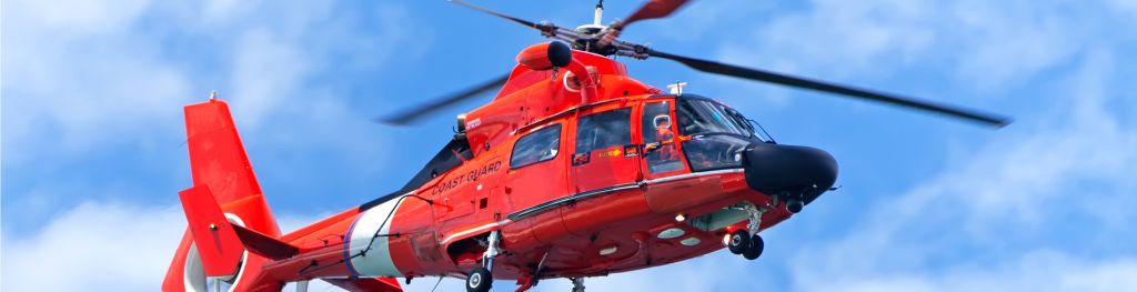 A red rescue helicopter moving in blue sky.