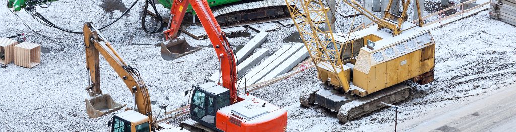 Heavy plant machinery at a halt and covered in snow