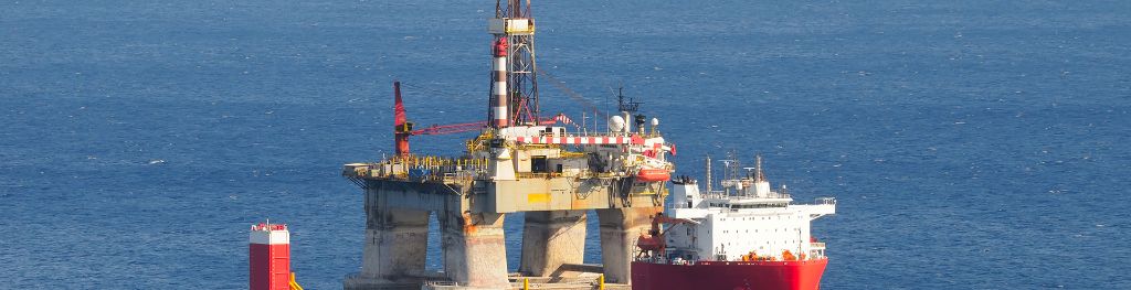 Heavy lift cargo transporting an oil rig in open sea.