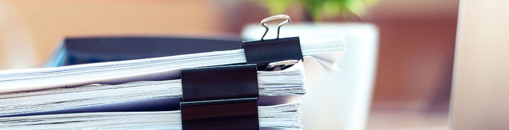 Stacks of paper on a desk.