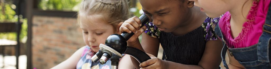 Three children looking in a microscope