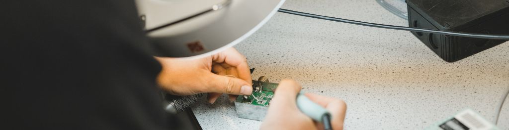 Close up view of someone soldering a circuit board.