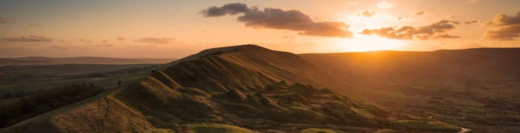 A view over a high green ridge in the evening sun