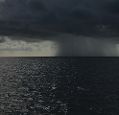 Rain falling on the horizon over the sea. Photo Brian Cook