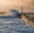 Storm waves crashing against a harbour wall