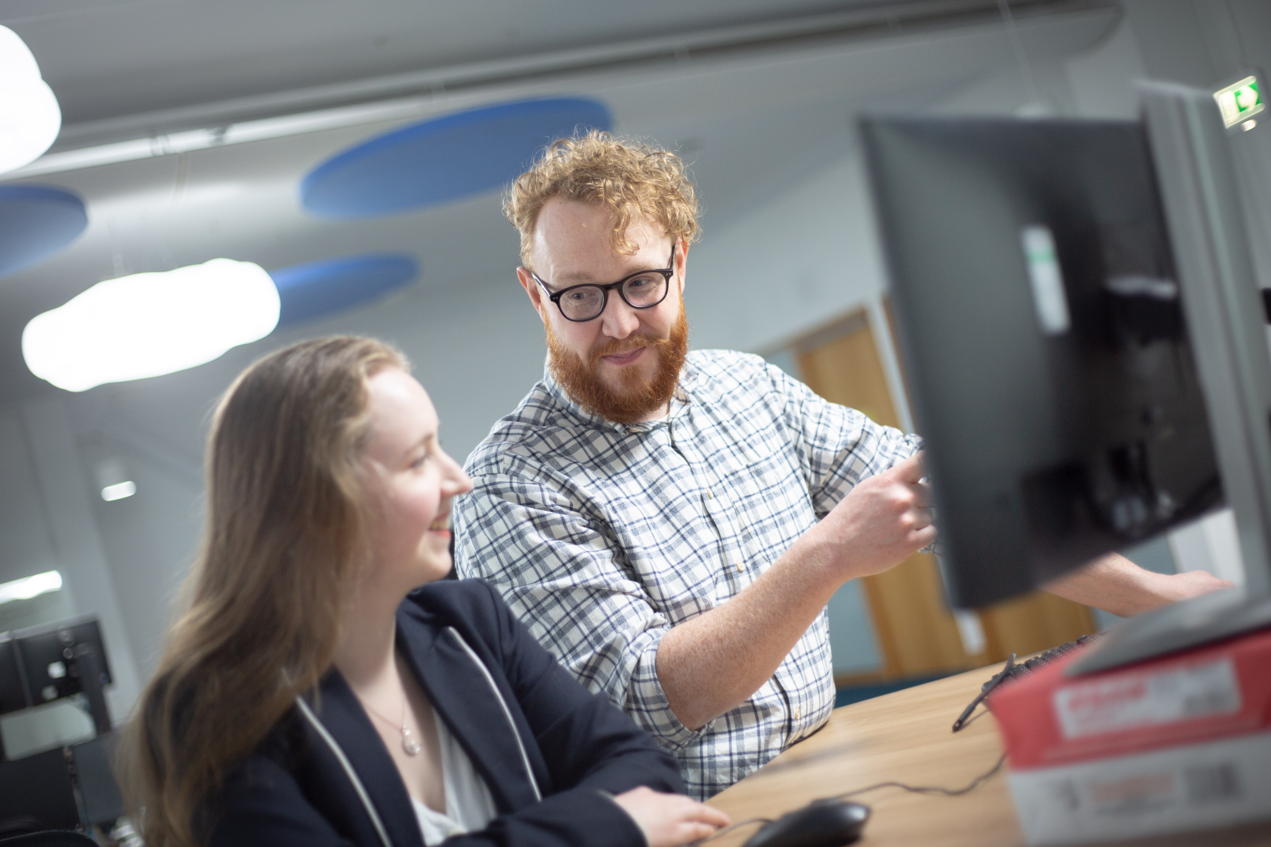 This image shows two people in front of a computer monitor
