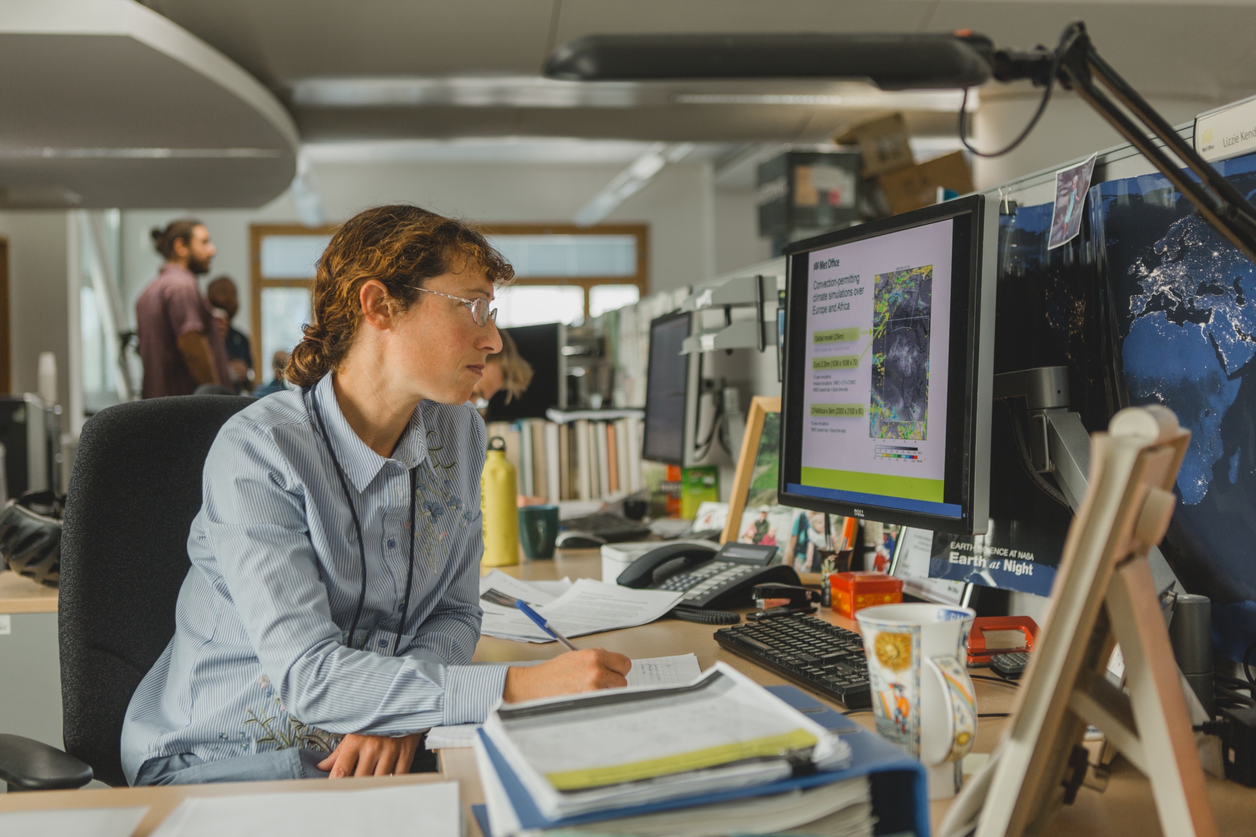 This image shows a person sat at a desk looking at a computer screen