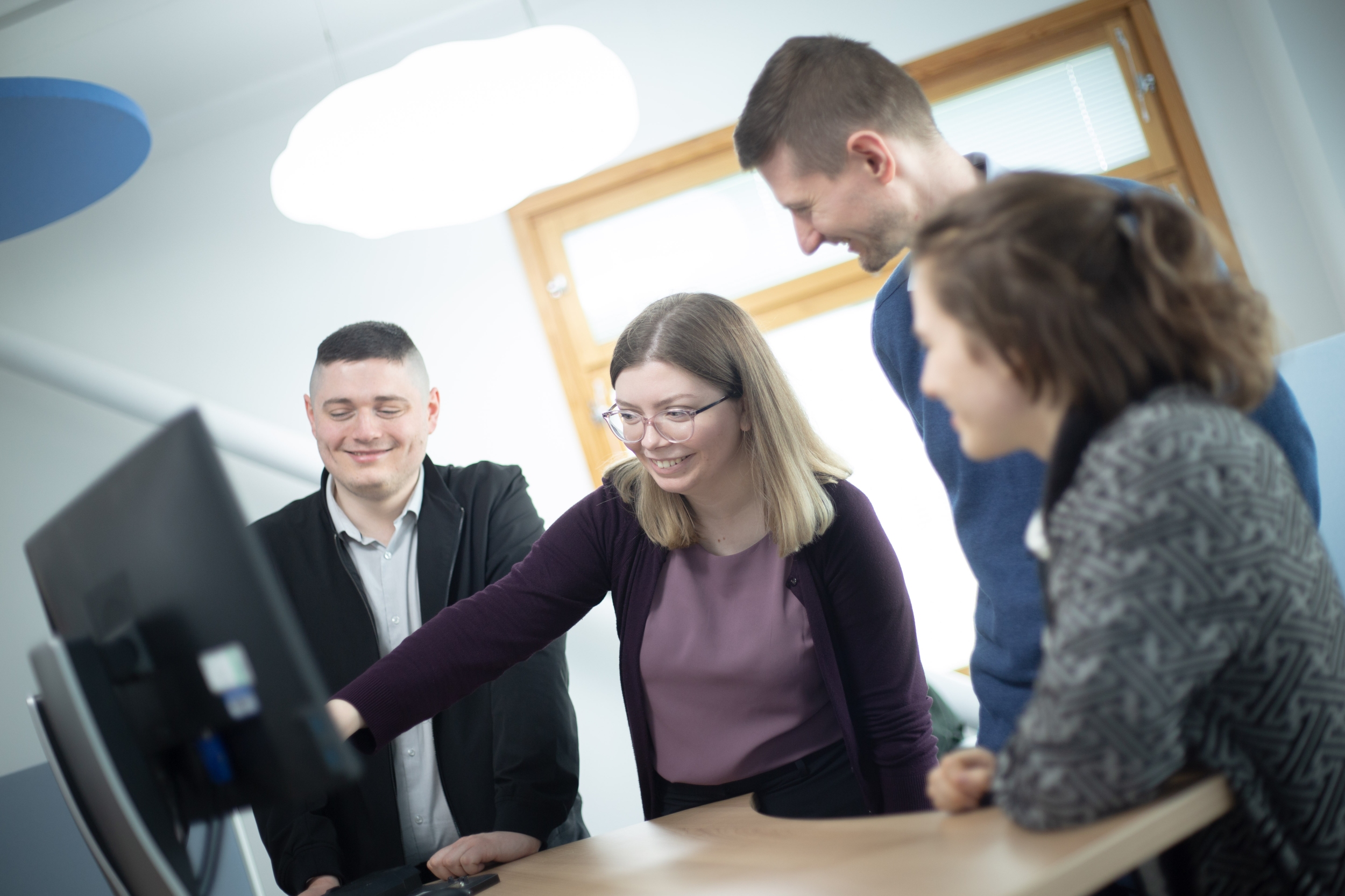 This image shows a small group of people around a computer screen