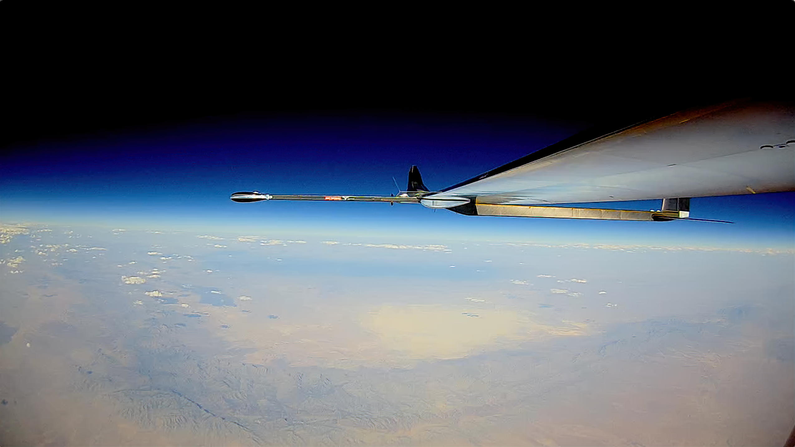 The wing of the PHASA-35 aircraft with the earth below and the darkness of space above at 66,000ft.