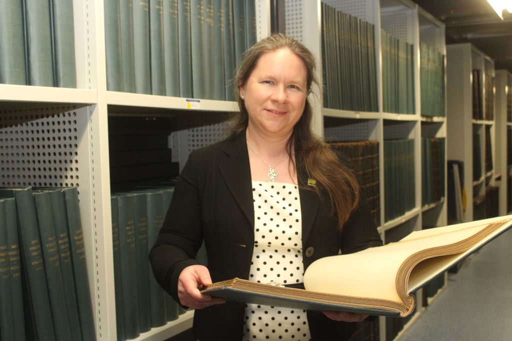 Dr Catherine Ross, Met Office Archivist, with the original rainfall records in the Met Office archive.