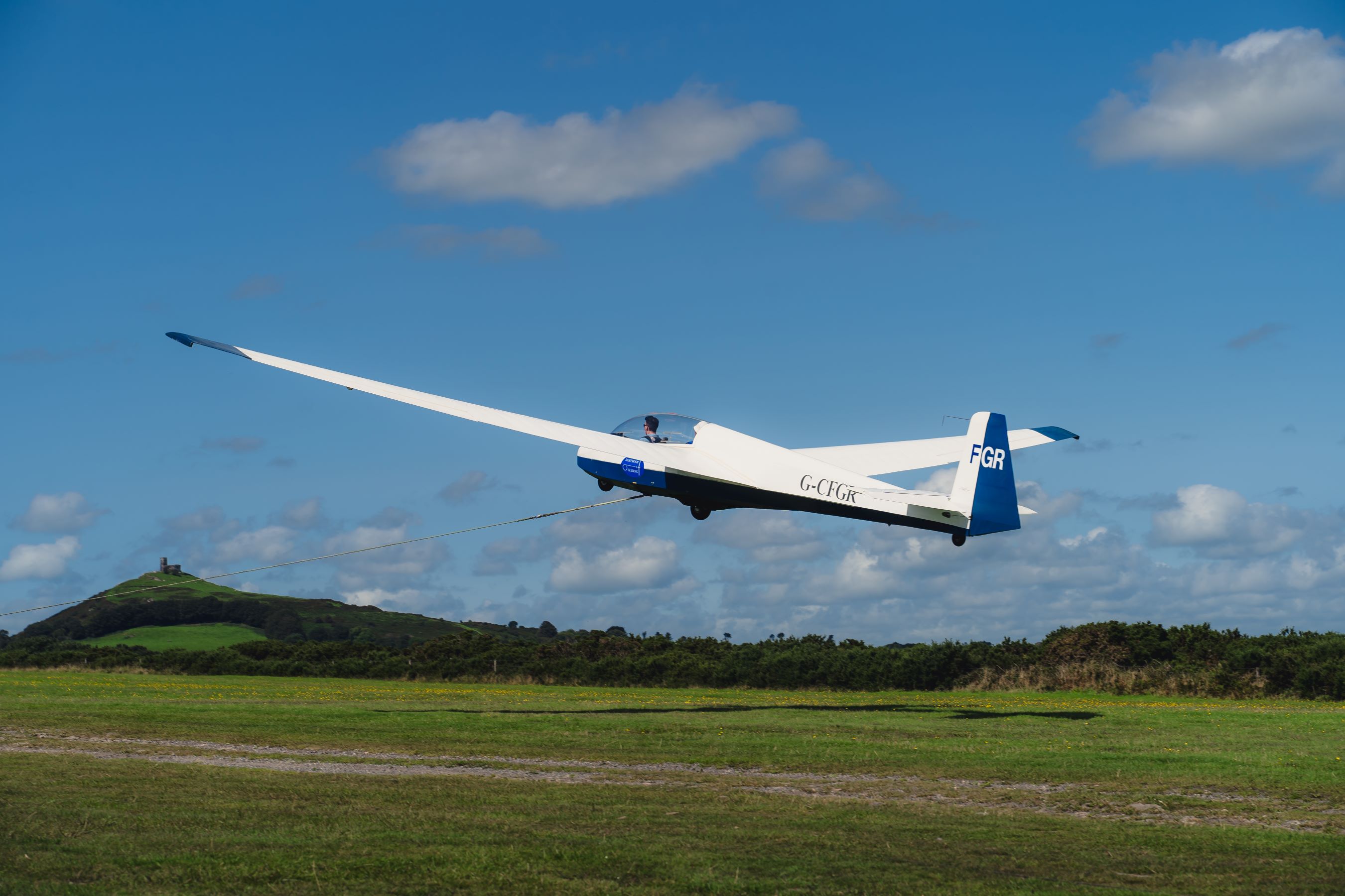 A view of behind a white glider just taking off