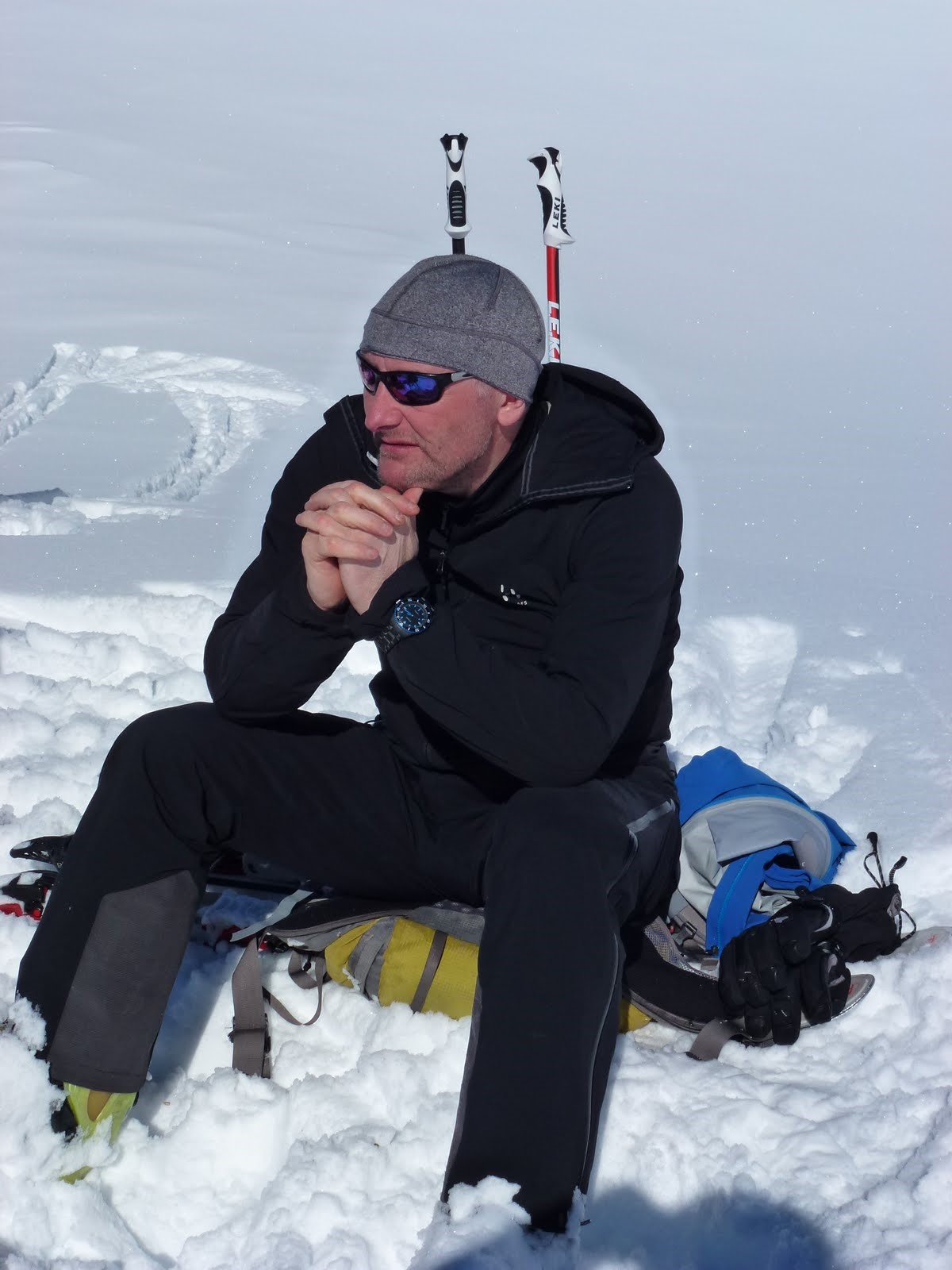 Mike Park of Mountain Rescue England & Wales sitting on a snowy mountain equipped with his mountain gear