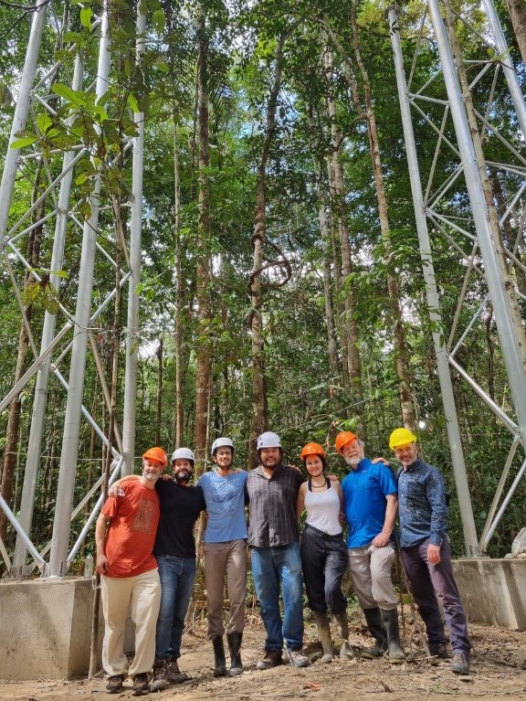 Project Oversight Group (POG) members including Dr Tomas Domingues, Professor Beto Quesada, Professor David Lapola, Dr Bruno Tanaka, Dr Sabrina Garcia, Dr Richard Norby and Professor Richard Betts at the inauguration of the AmazonFACE site. Behind them is the first site with six tower foundations and two towers that will soon form one completed ring.