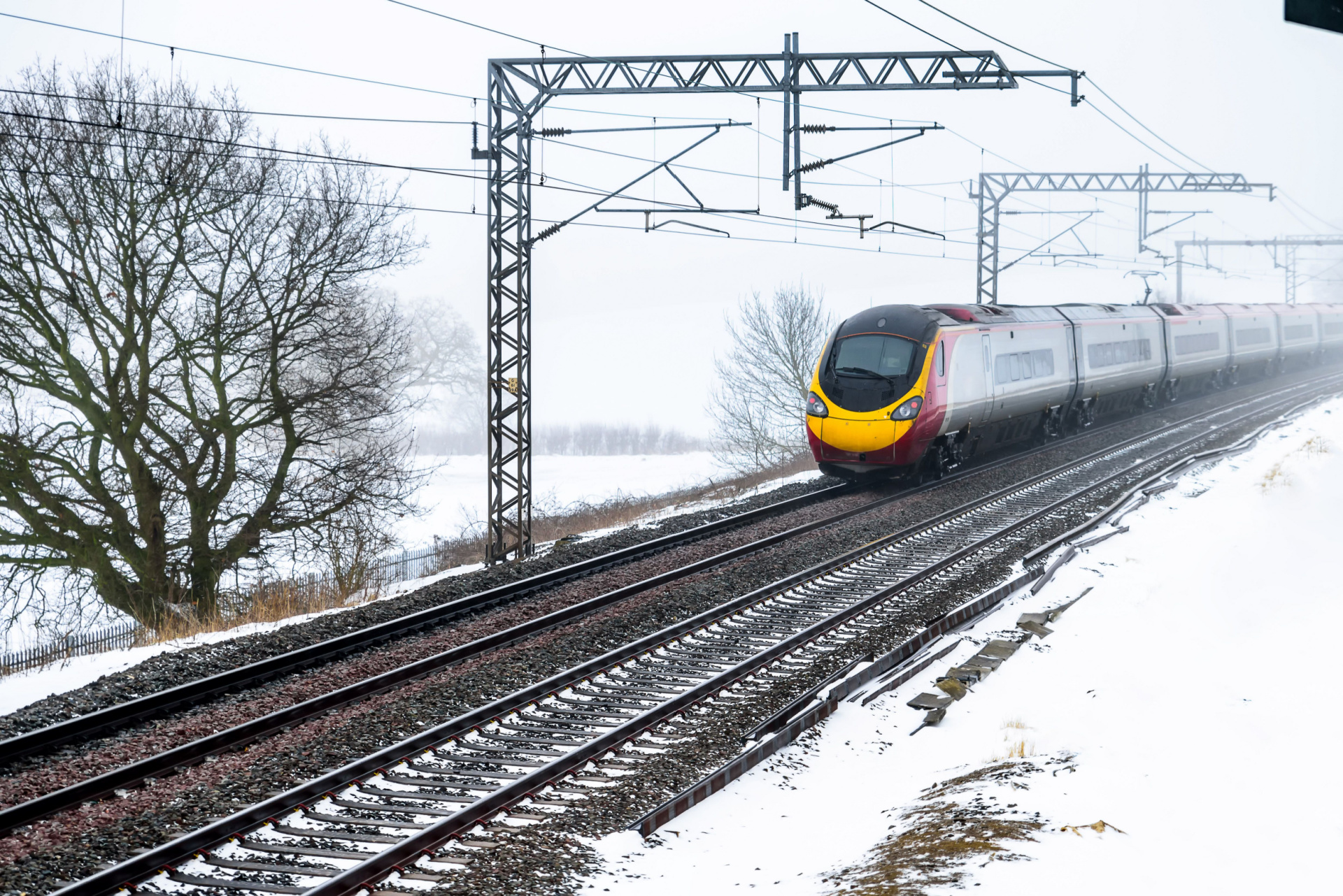 Train moving along tracks in the snow.