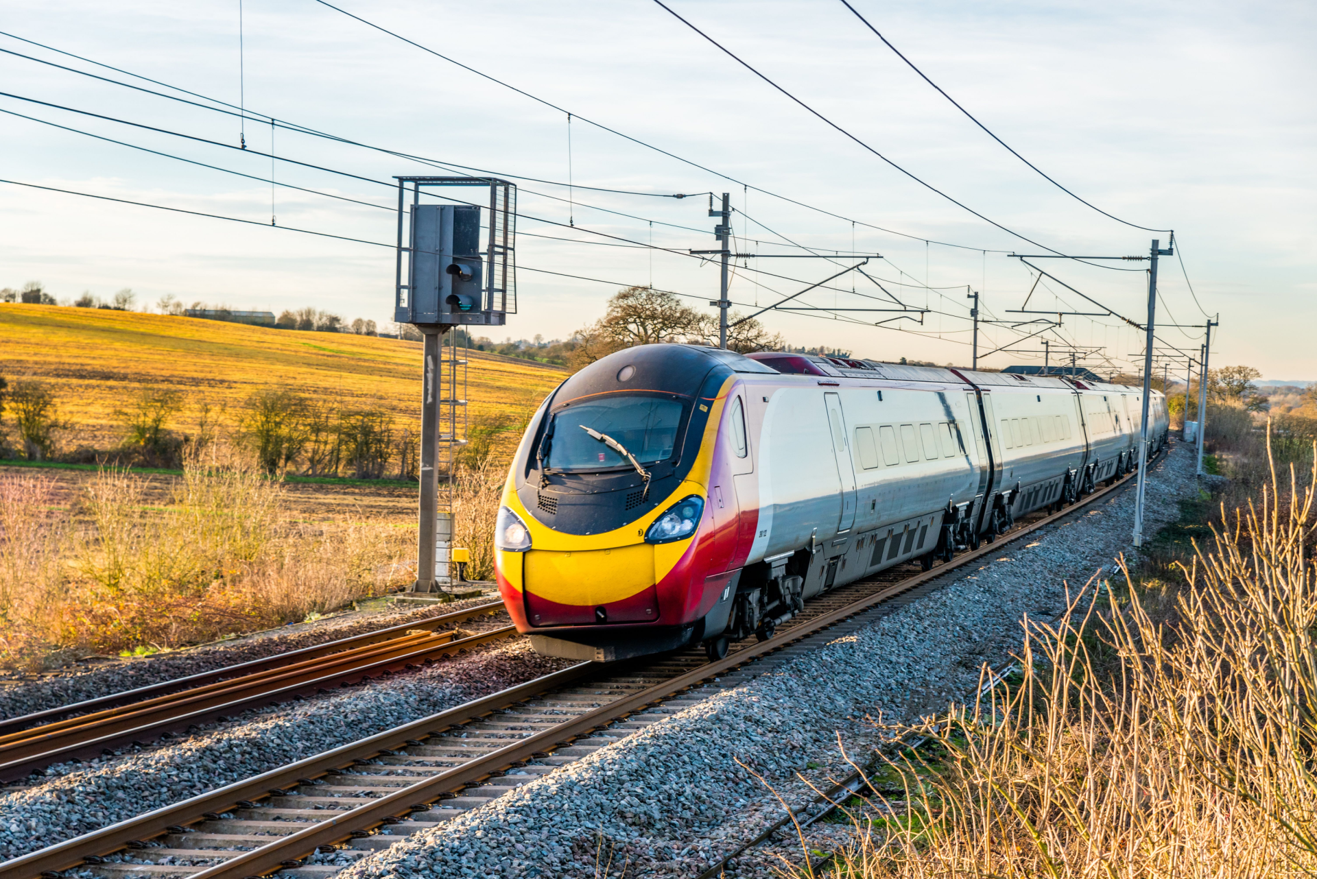 A train moving along tracks with a field in the background.