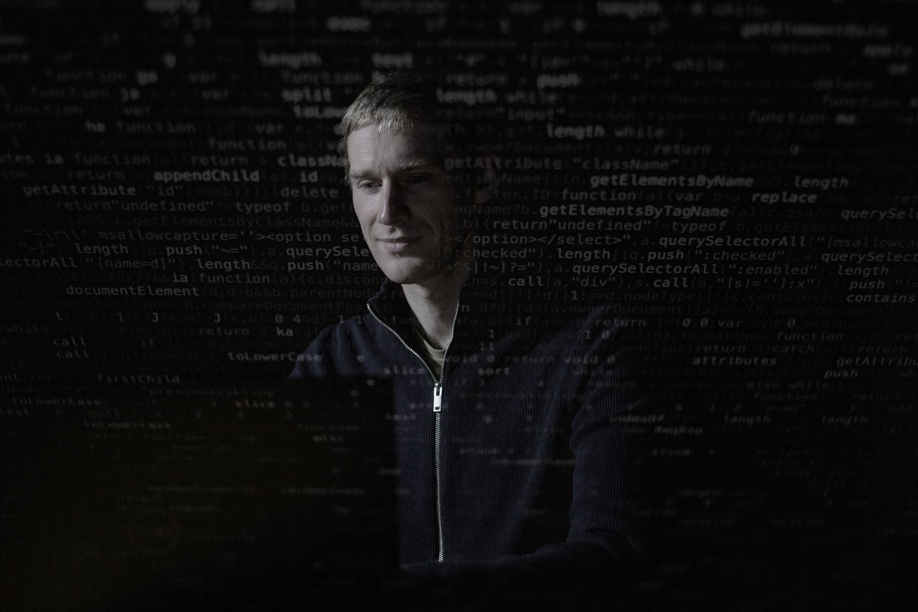 Theo McCaie working on a computer surrounded by code.