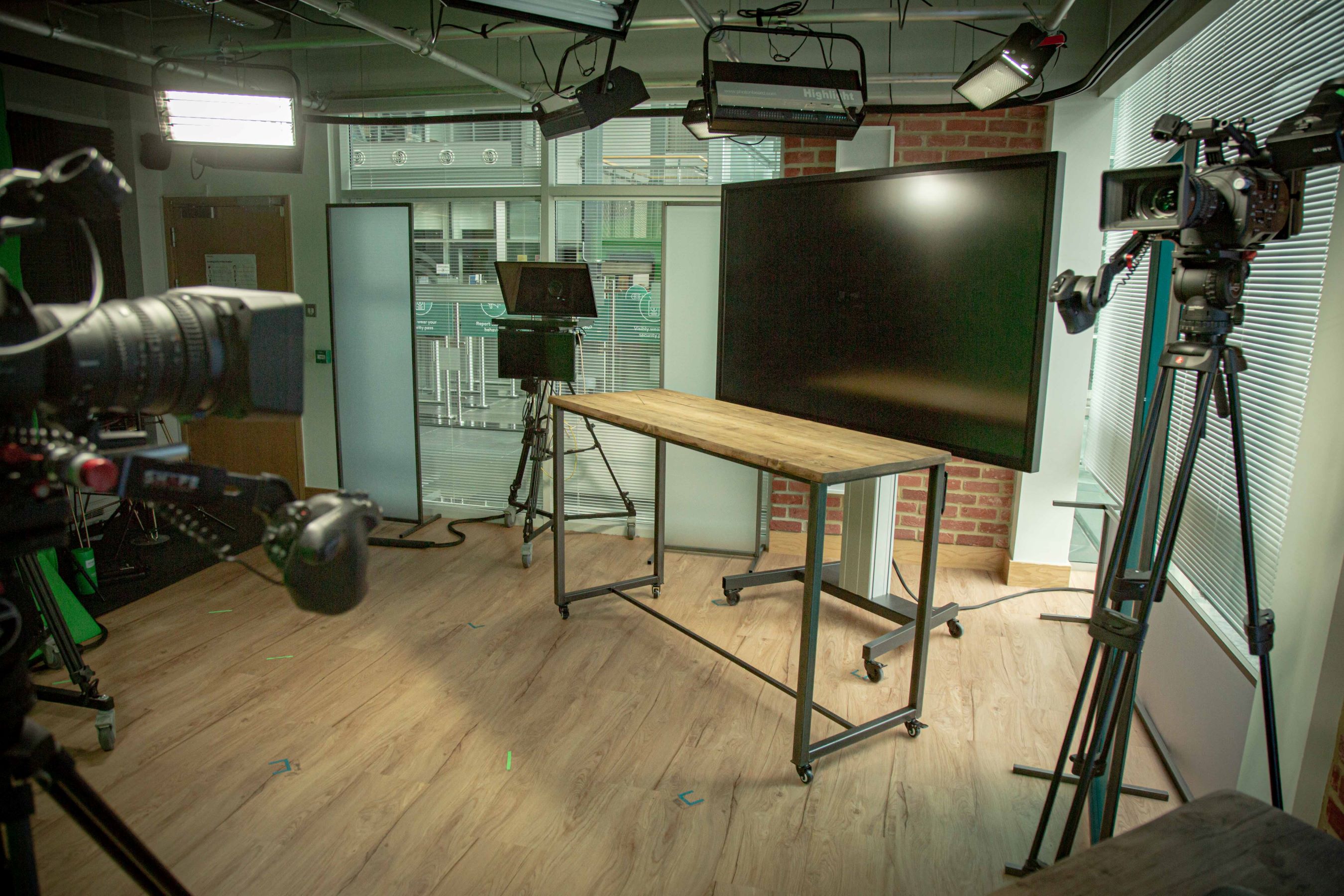nside the Met Office studio, looking from behind the cameras to a large screen behind a table