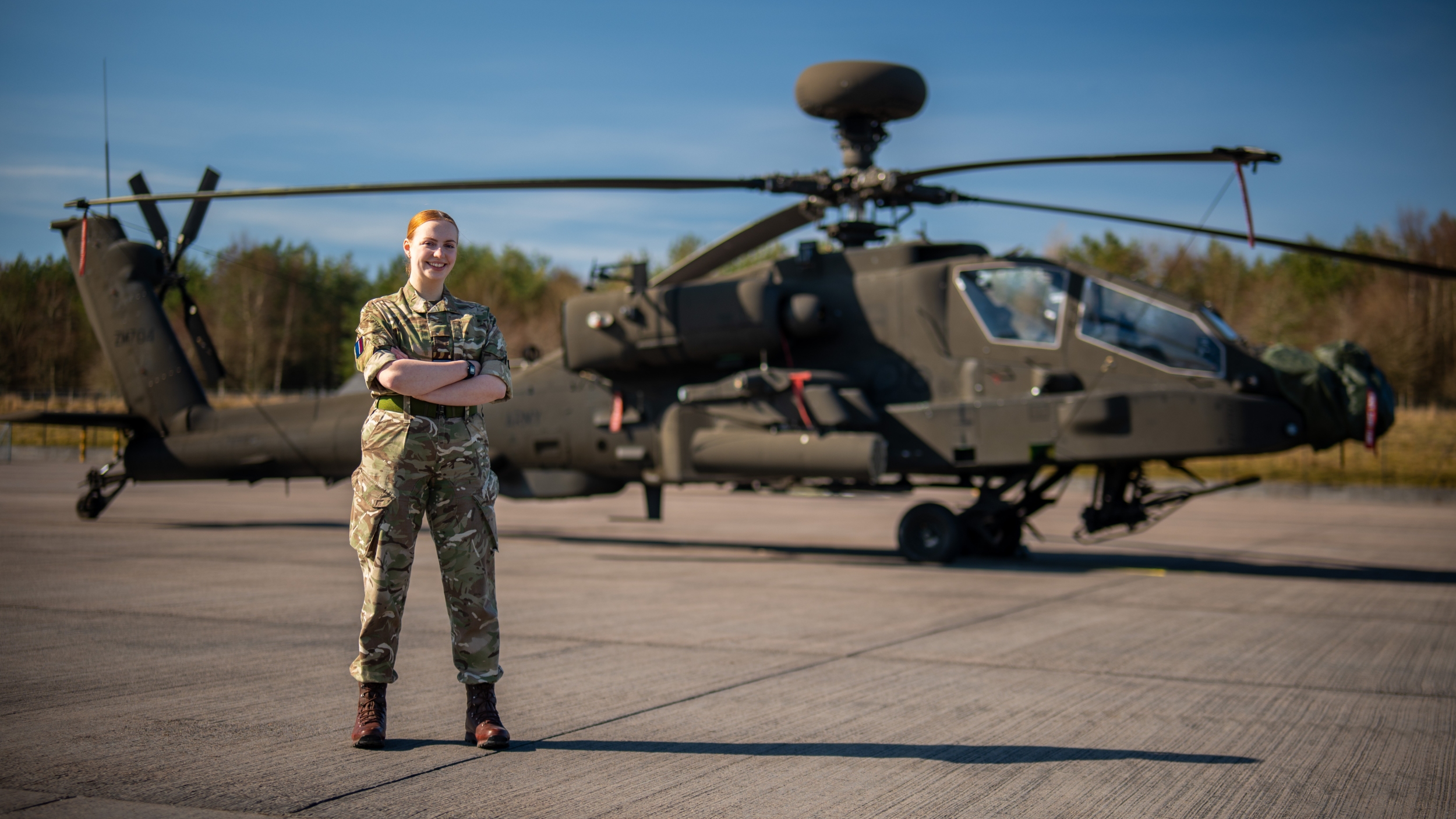 Person wearing military uniform standing in front of helicopter